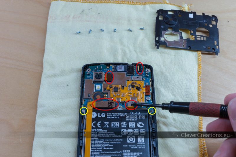 Four circled flex cable connectors and two circled antenna connectors on the motherboard of a Nexus 5 phone.