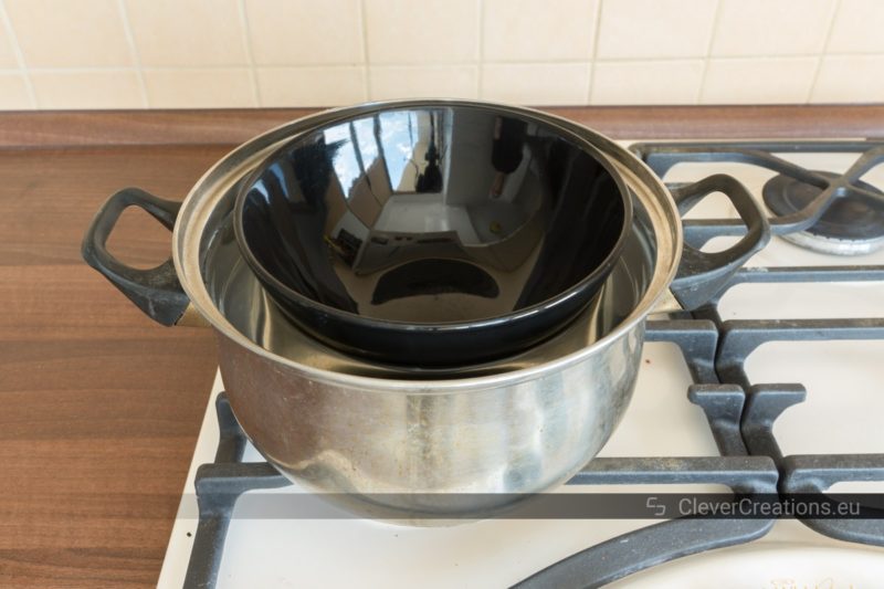 A bain-marie made out of a bowl and a saucepan on top of a stove.