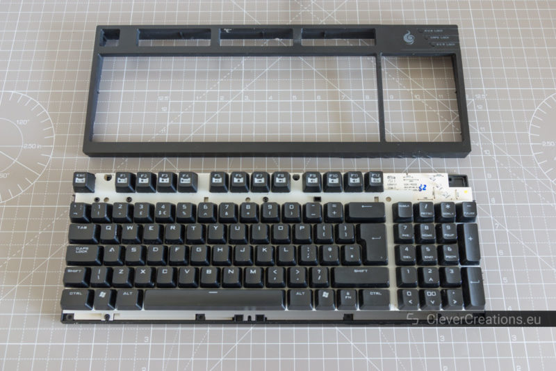 Top view of a Cooler Master QuickFire TK keyboard with the top plastic cover removed and placed above the keyboard.