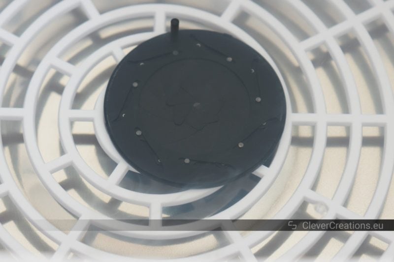 Close-up of a camera lens iris diaphragm placed inside of an ultrasonic cleaner.