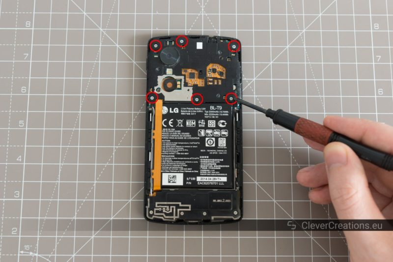 Six circled screws on the inside of a partially disassembled Nexus 5.