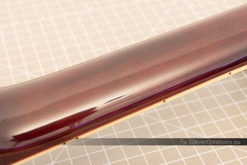 Close-up of high-gloss polyurethane lacquer on the back of a guitar neck.