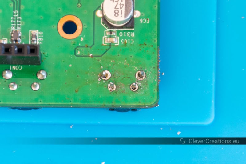 A desoldered button on the solder side of a PCB.