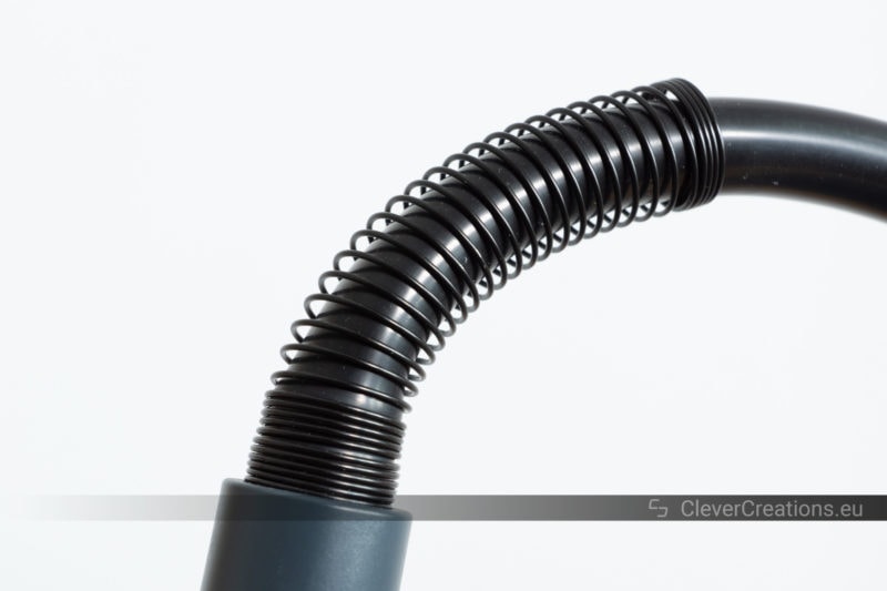 A black flexible rubber hose with a spring over it for strain relief.