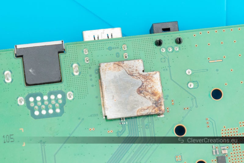 Close-up of corroded shielding on a printed circuit board.