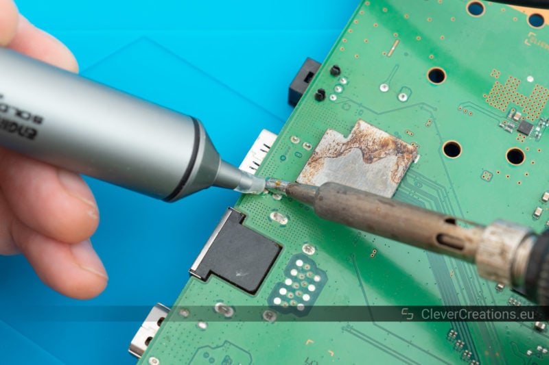An Engineer SS-02 solder sucker and soldering iron being used to remove solder from a broken HDMI port.