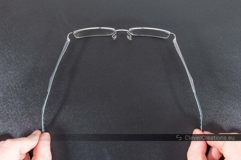 A pair of glasses with spring hinges that extend further than the traditional 90 degrees of barrel hinges.
