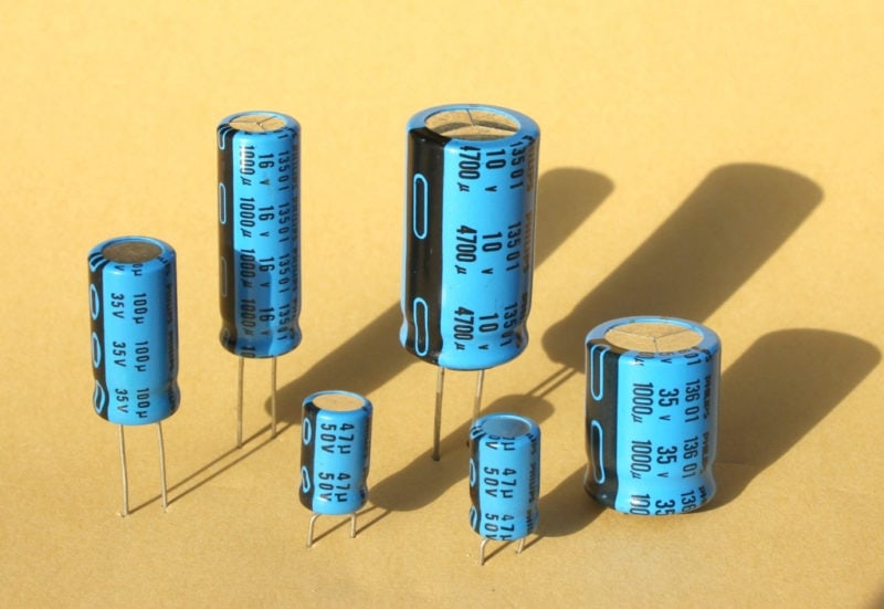 A variety of electrolytic capacitors stuck in cardboard.