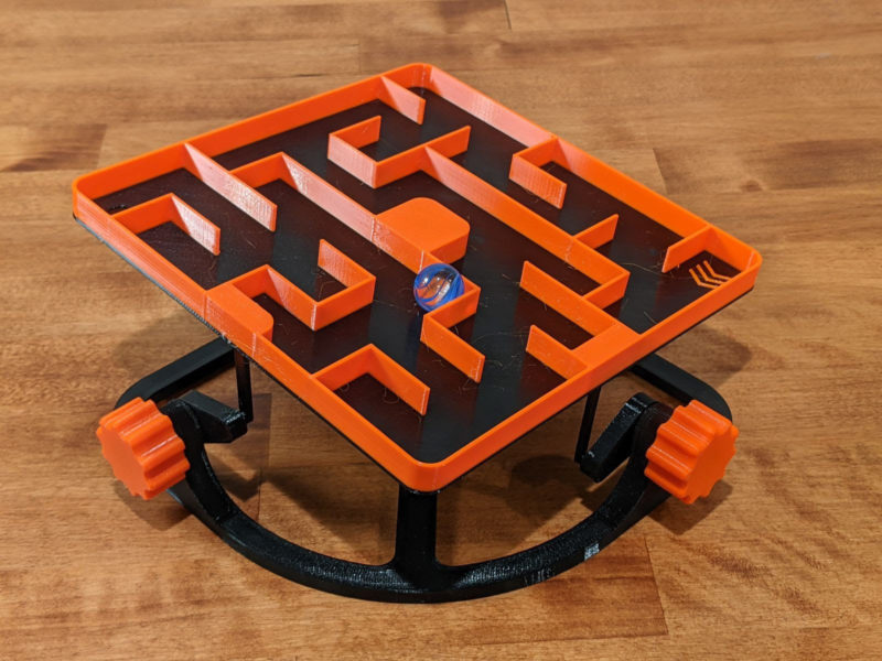 A marble maze 3D printing idea in orange and black