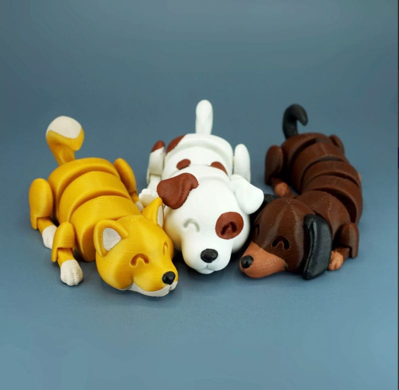 Three cute articulating multicolor dog figurines