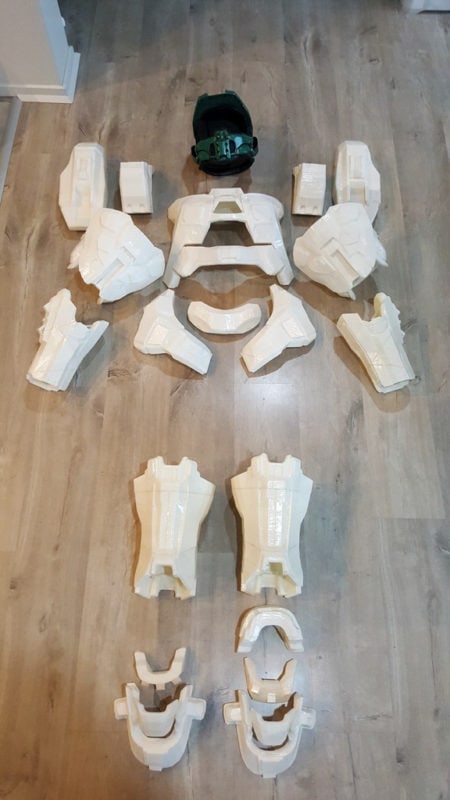 Components of a 3D printed Halo Master Chief costume laid out on a floor.