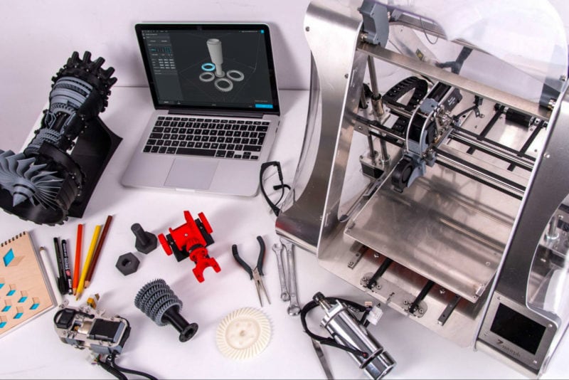 A collection of 3D printing-related objects and accessories on a white desk