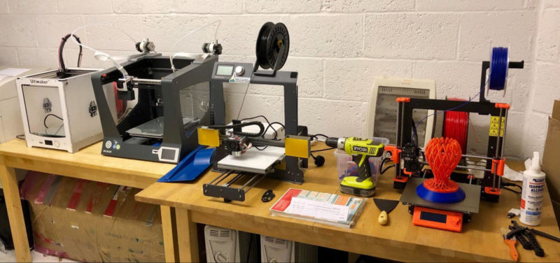 A workshop with various 3D printers in a garage
