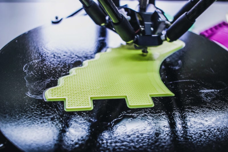 A delta 3D printer printing with green filament