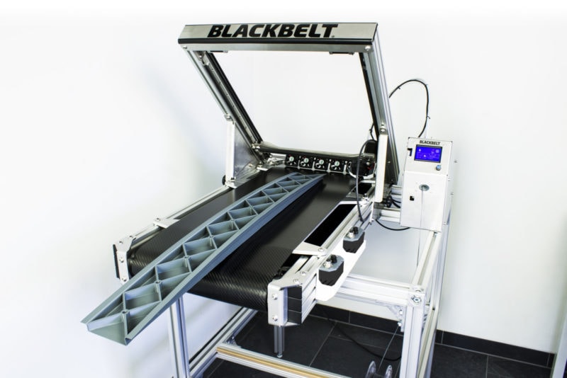 A belt 3D printer with a long printed item on the conveyor