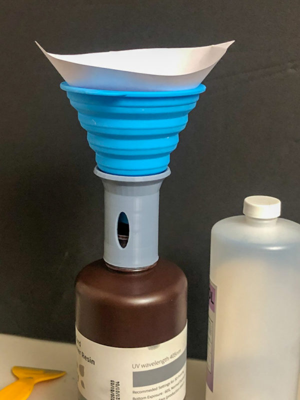 A 3D printed resin filter funnel holder on top of an open bottle