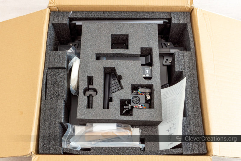 An open box with foam and a variety of unassembled 3D printer components.