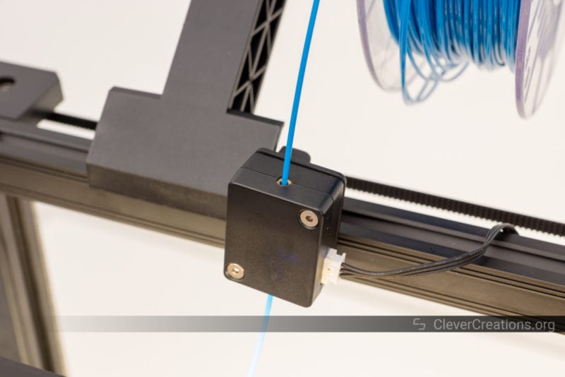 A filament runout sensor with blue PLA filament running through it