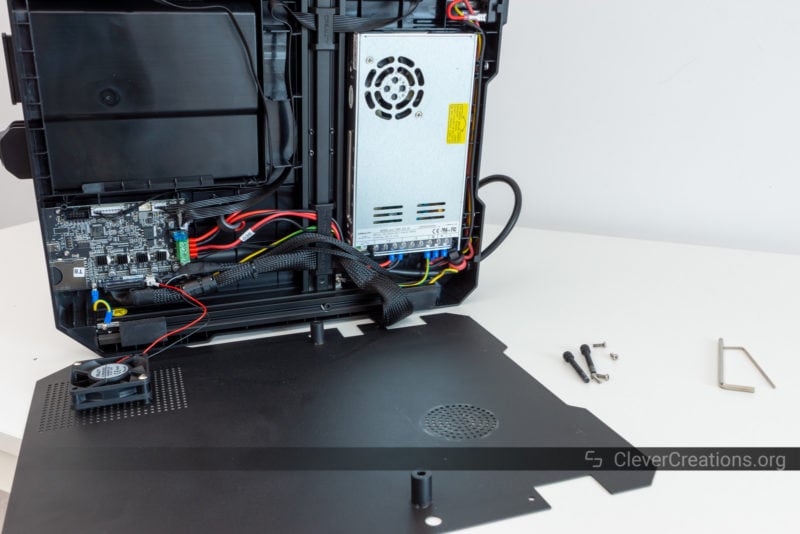 An open 3D printer electronics compartment with its lid removed.
