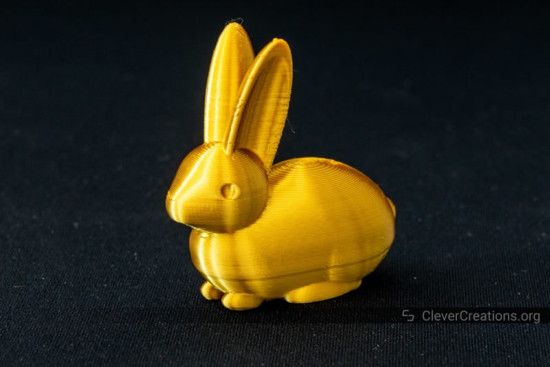 A close-up of a golden 3D printed bunny