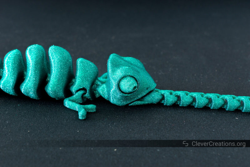 A close-up of the face of a green chameleon toy