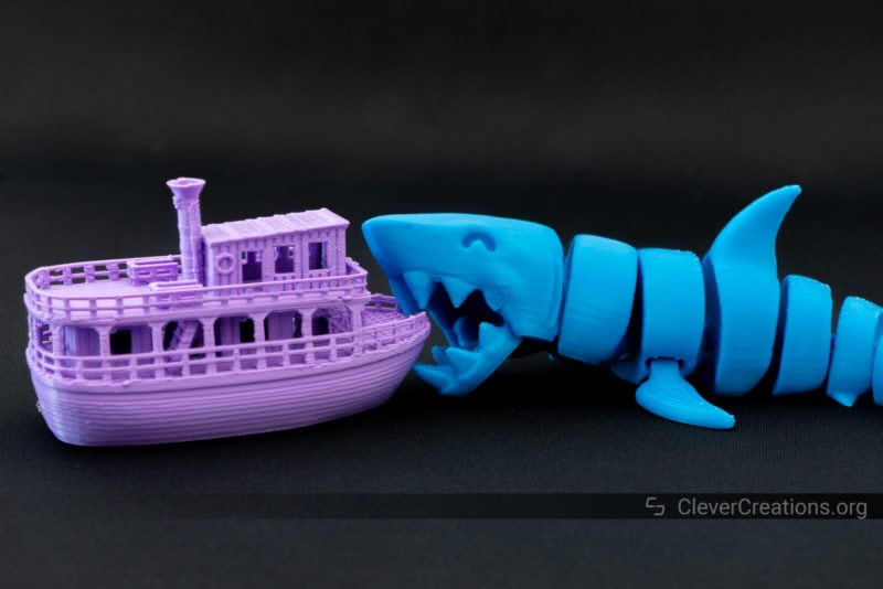 A model shark taking a bite out of a model river boat