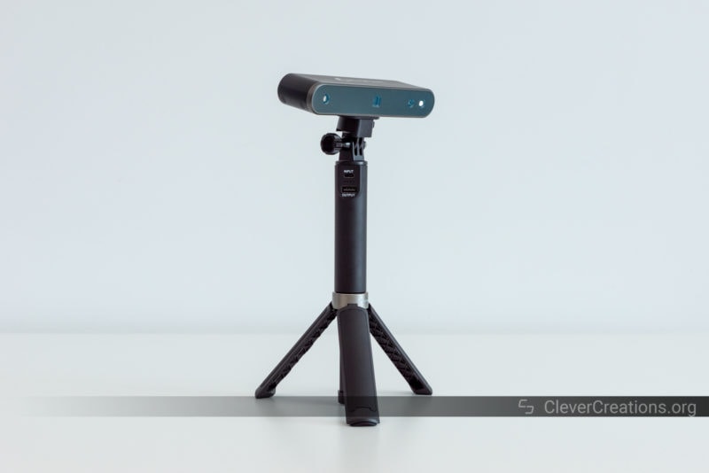 A 3D scanner mounted on top of a power bank, which on turn is mounted on a tripod