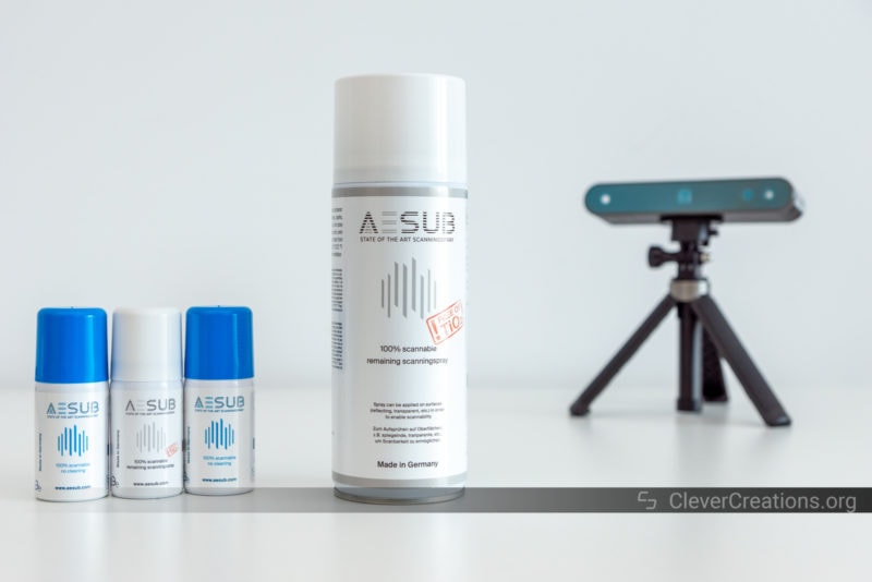 A selection of AESUB scanning sprays in front of a Revopoint 3D scanner