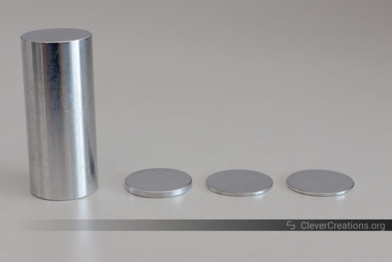 Four cylindrical metal spacers next to each other on a white surface