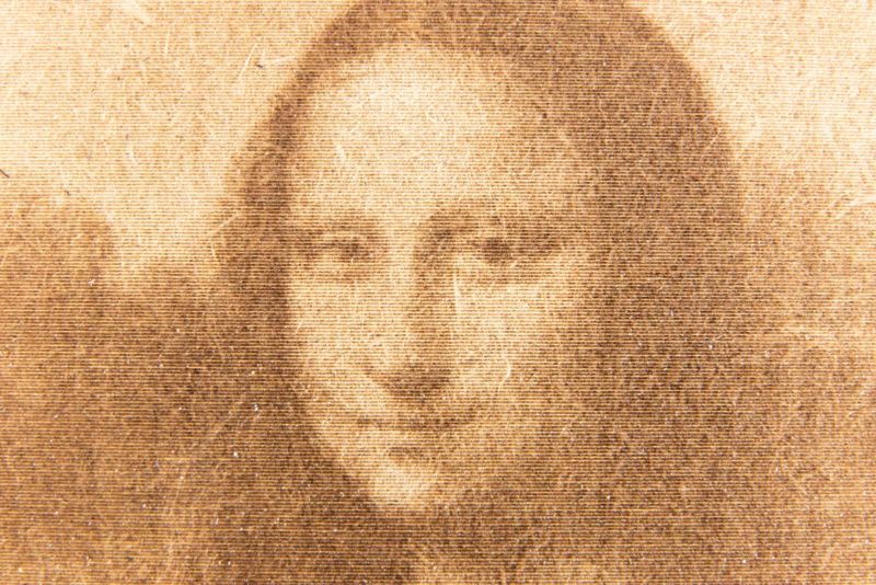 A close-up of a laser engraving of the Mona Lisa painting