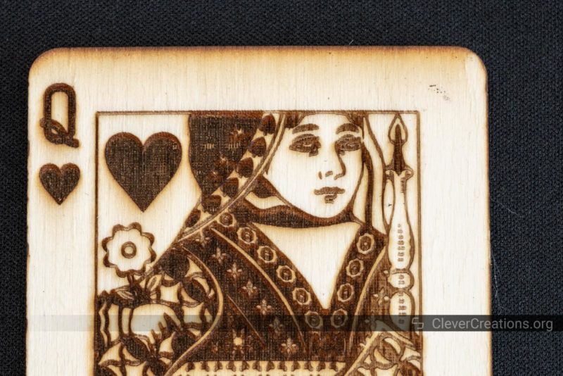 A close-up of a queen of hearts laser engraving on Birch Plywood