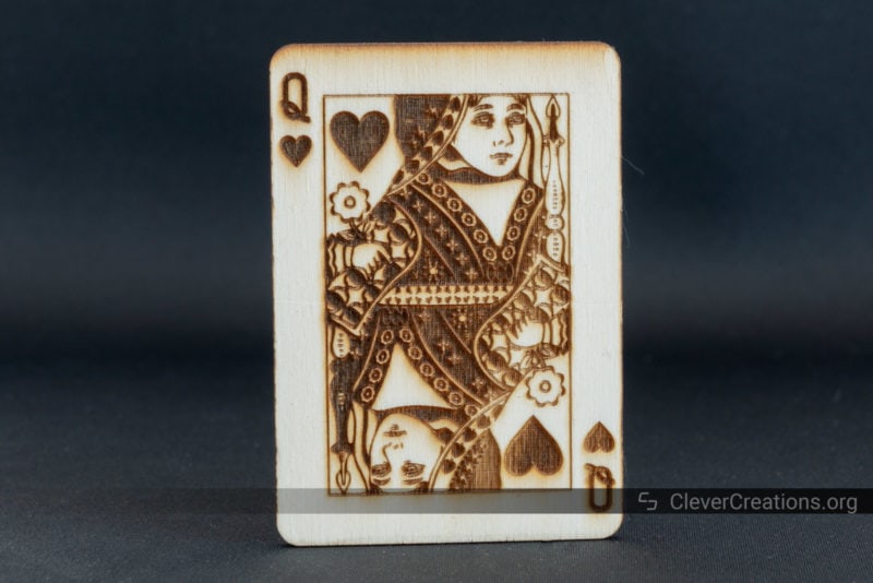A queen of hearts playing card engraved on Birch wood