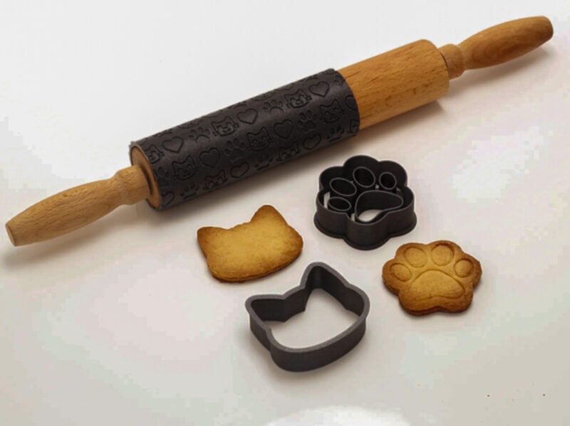 Two black 3D printed cookie cutters and other kitchen accessories
