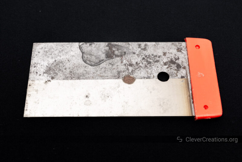A rusty scraper tool with half of the rust removed with the use of a 1064nm laser.