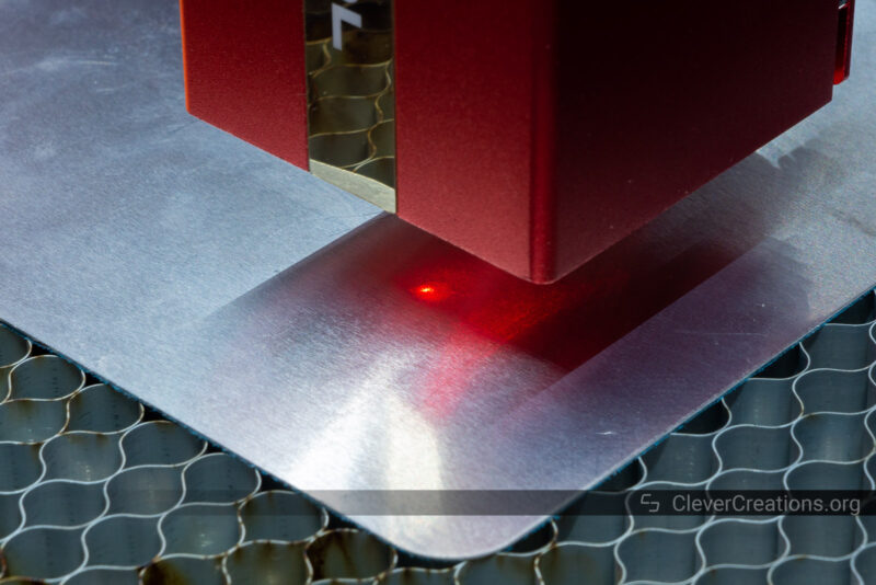 A small red dot for alignment purposes eminating from a laser head onto a steel surface
