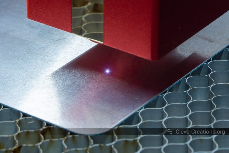 A large white light dot from a laser on a steel plate