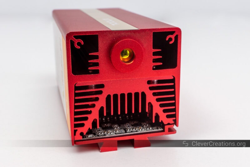 A red aluminum laser head with lens, heatsink, and internal PCB visible