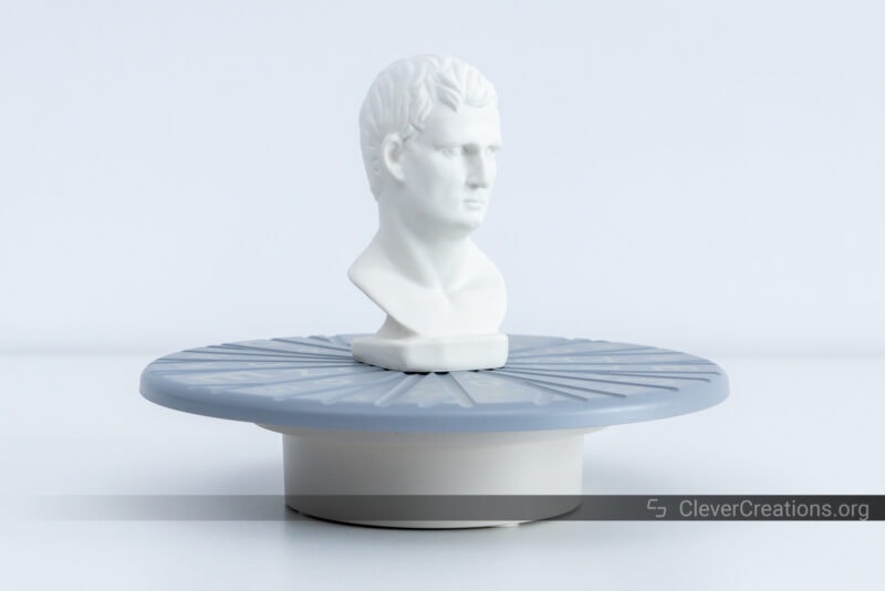 A white gypsum statue on a 3D scanner turntable