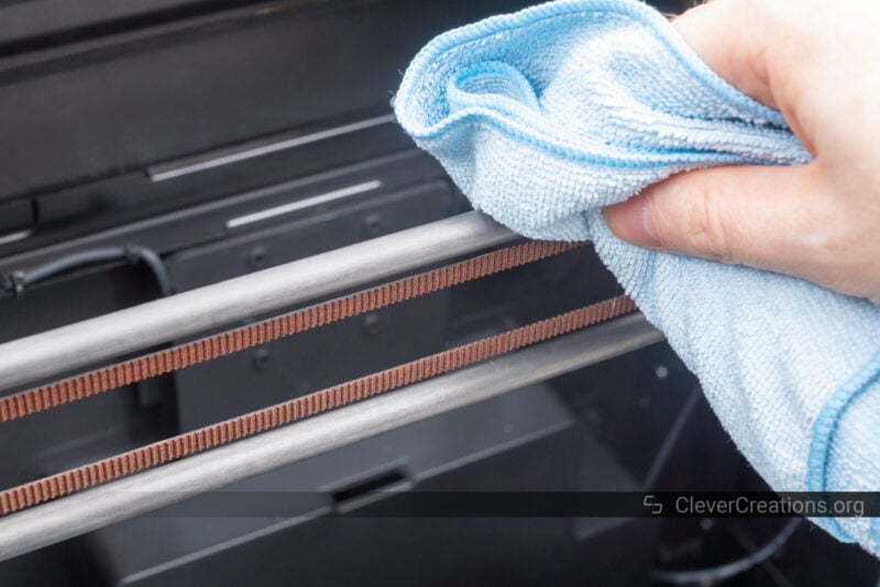 A hand using a microfiber cloth to clean a carbon fiber rod