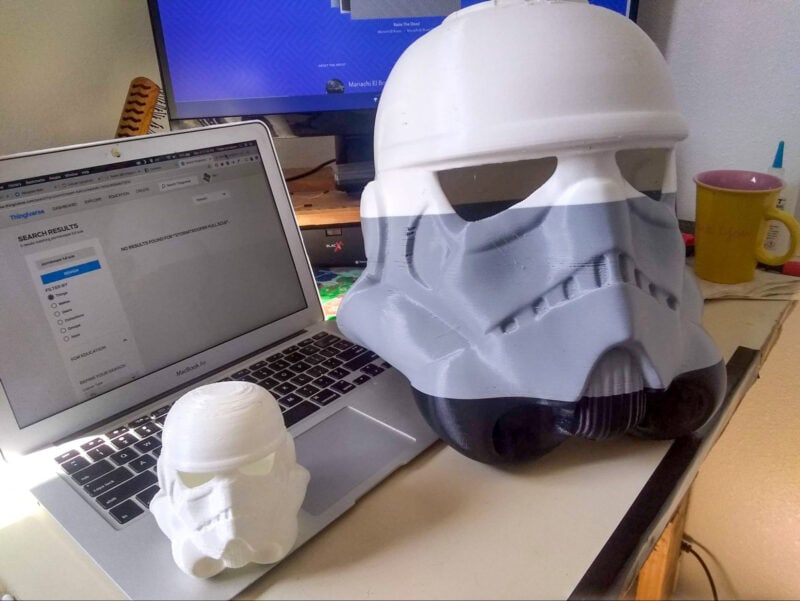 A large 3D printed helmet next to a smaller version