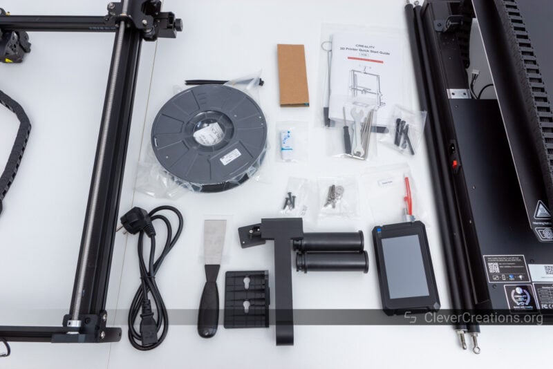 A collection of components laid out on a table during the CR-M4 3D printer unboxing