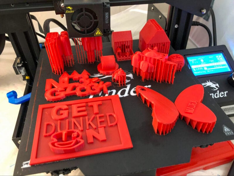 A collecting of red 3D printed parts on a print bed