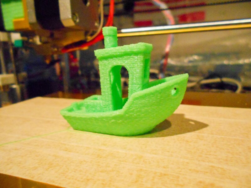 A green 3D printed benchy made with filament that needed to be dried