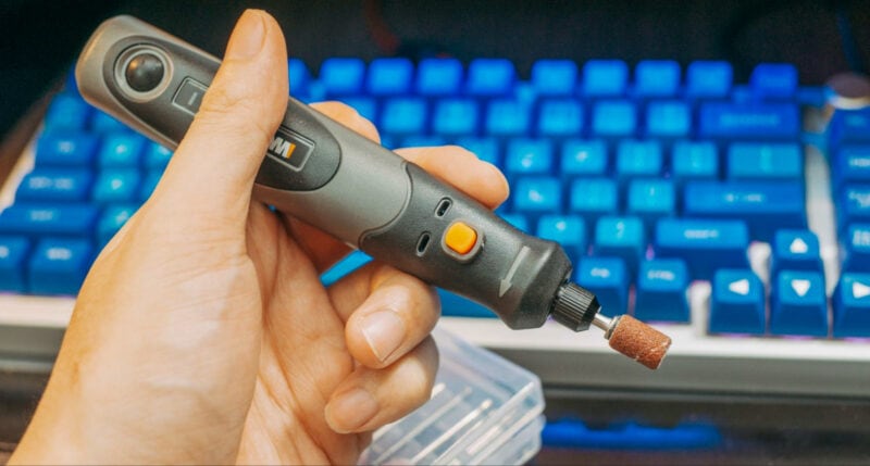 A hand holding a rotary tool for sanding 3D prints