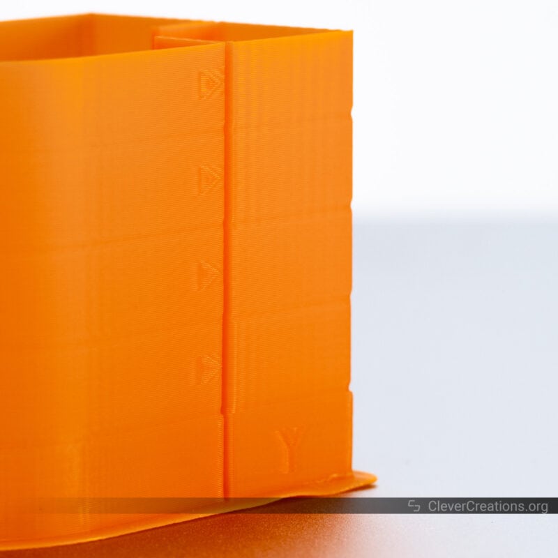 An orange vibration compensation calibration print with varying levels of ringing