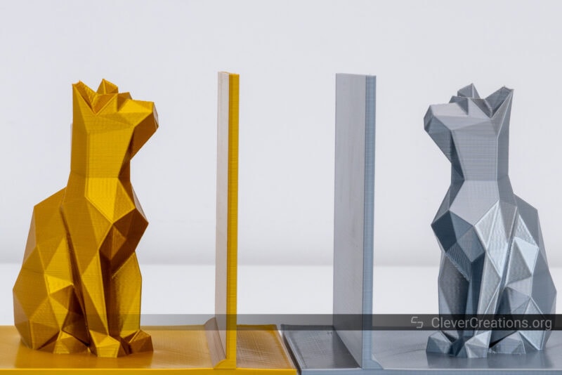 3D printed cat bookends in gold and silver