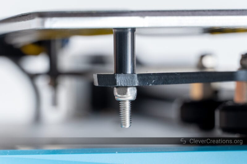 A print bed mounted with long bolts, rigid spacers, and Locknuts