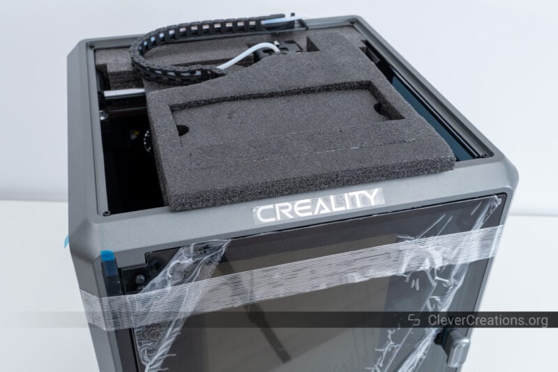 A piece of black foam sticking out of a Creality 3D printer during the unboxing process