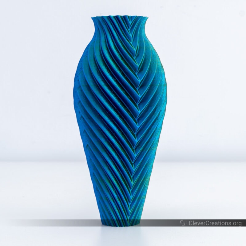 A dual-color blue and green 3D printed vase with visible artifacts on its external shell