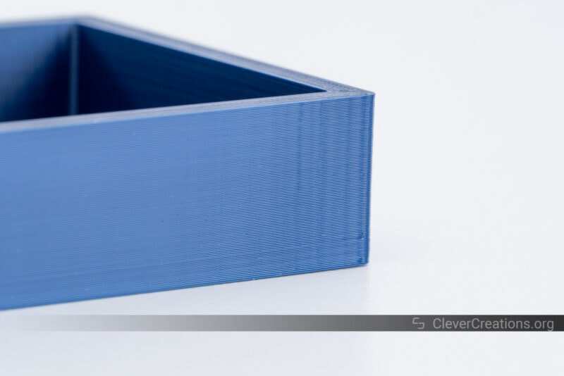 A blue ABS 3D print of a parts tray with ringing